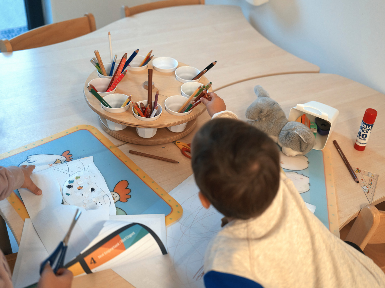 Ein Kind greift nach Buntstiften